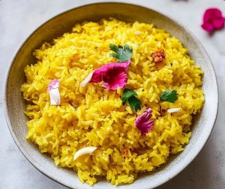 A bowl of garlic turmeric rice, garnished with herbs, ready to serve.