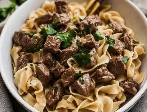 Bowl of easy beef and noodles garnished with herbs