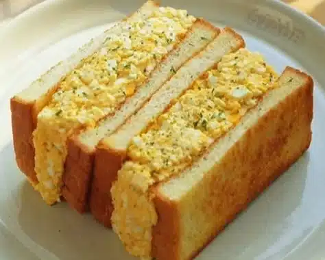 Delicious homemade egg sandwich on a plate with fresh vegetables