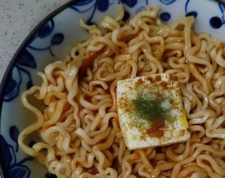 Bowl of creamy garlic butter ramen with green onions and soft boiled egg