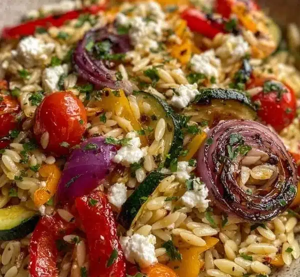 Orzo salad featuring roasted vegetables and crumbled feta cheese