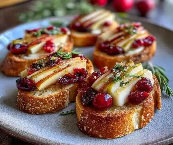 Pear Brie Cranberry Crostini 9 Delicious Pear Brie Cranberry Crostini topped with fresh cranberries and sliced pear.