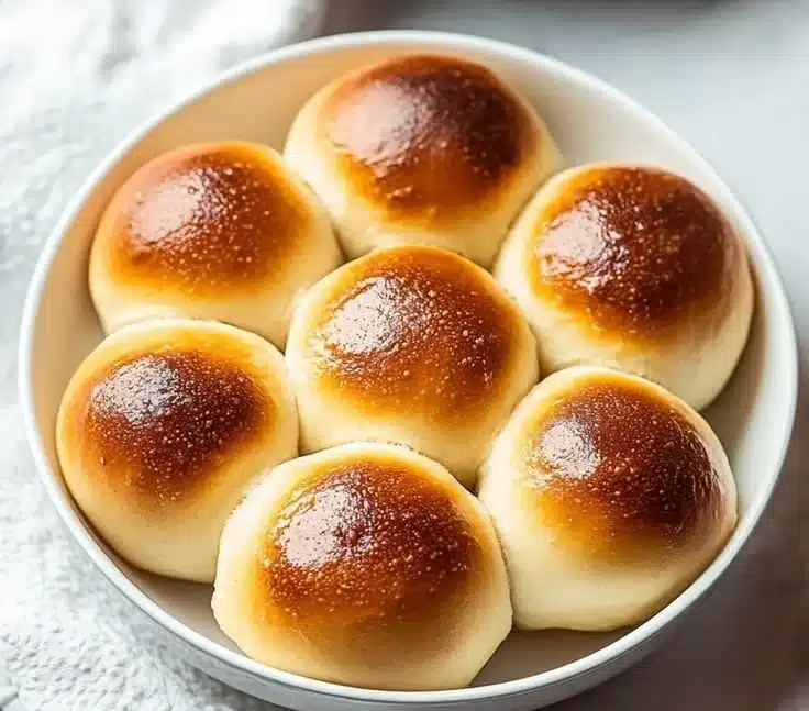 Soft gluten free dinner rolls fresh out of the oven, golden and fluffy.