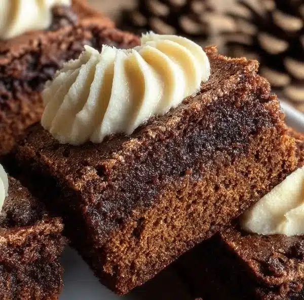 Delicious spiced chewy gingerbread brownies with creamy frosting on top