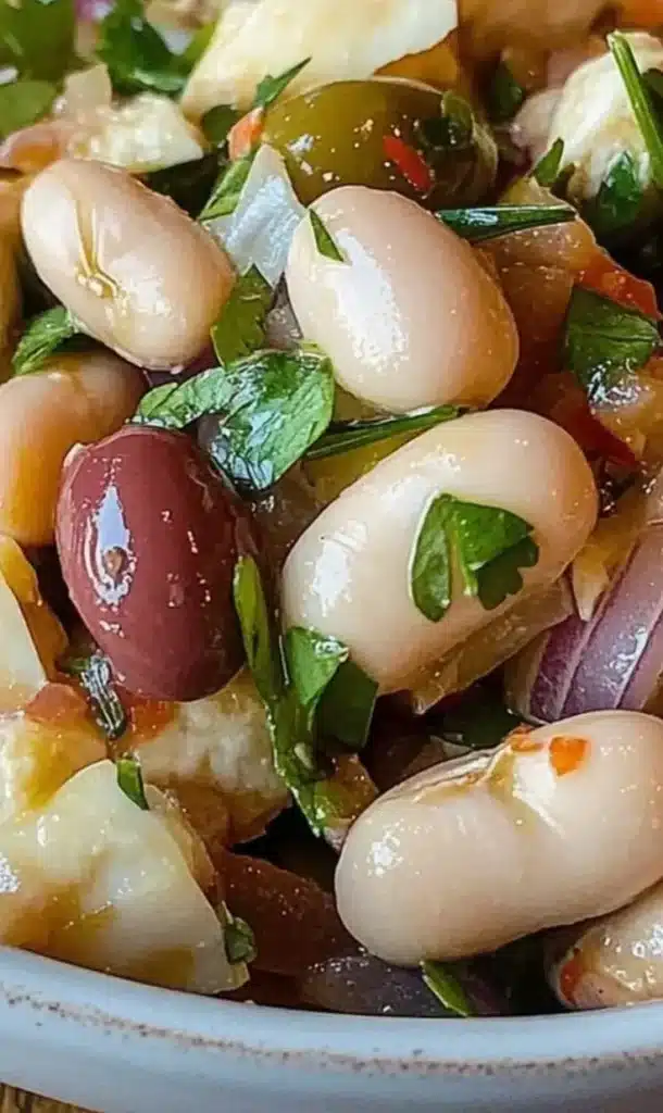 Easy Mediterranean Bean Salad with olives and onions in a colorful bowl