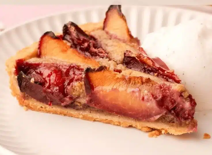 Delicious homemade plum tart topped with fresh plums and golden crust