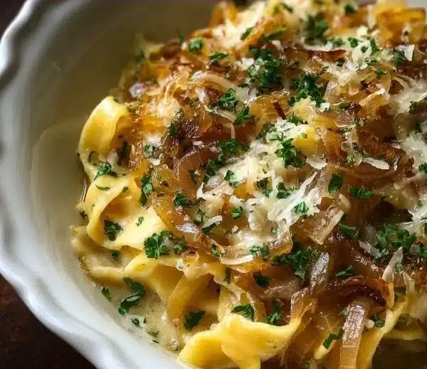 Bowl of French onion soup pasta topped with Gruyère cheese