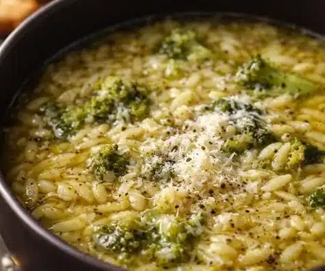 Bowl of Italian broccoli soup garnished with herbs and served with a slice of bread